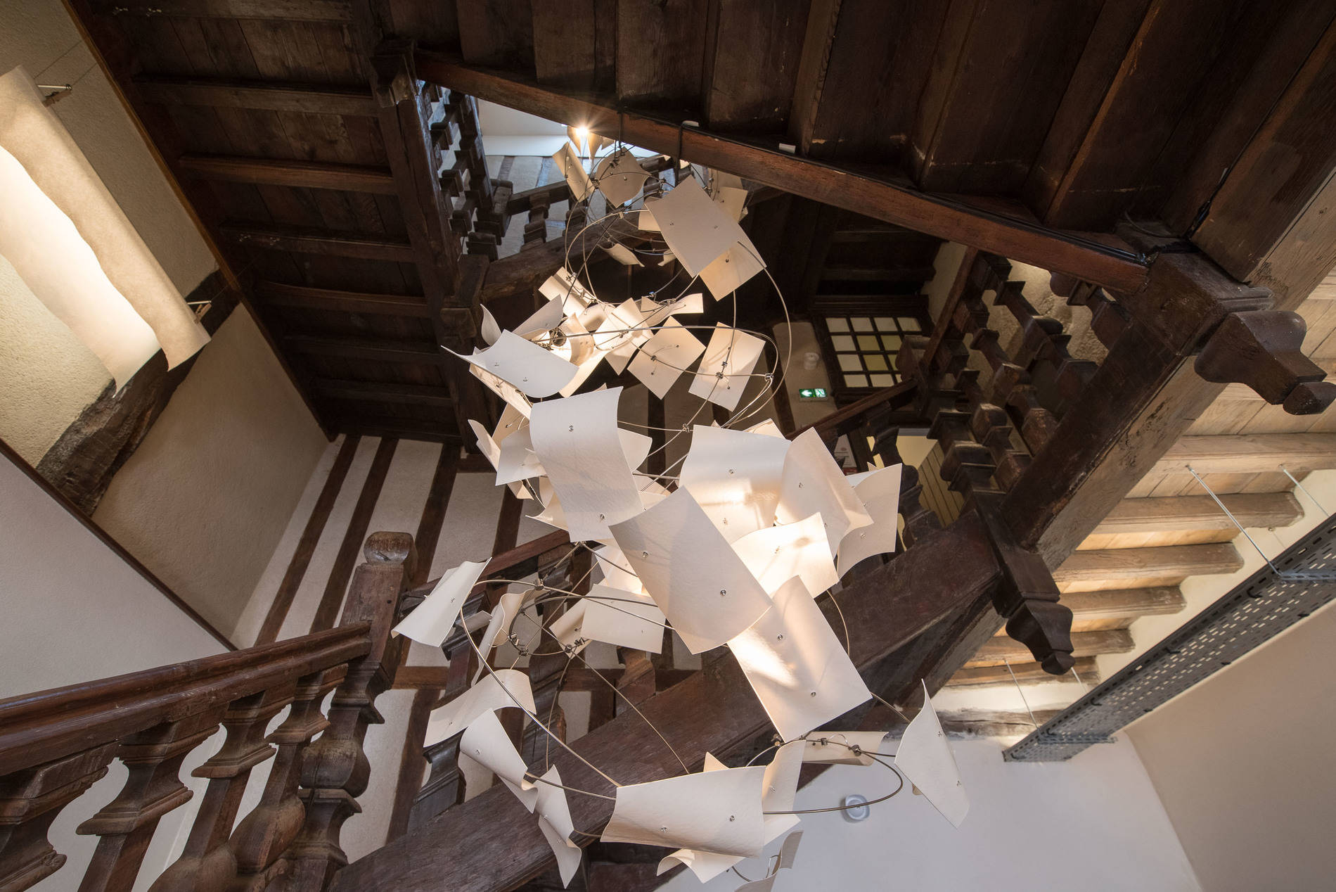 Passage secret - création sur mesure pour l'escalier d'un tiers lieu d'une sculpture suspendue en porcelaine blanche et structure inox. Création de la structure lumineuse en led.